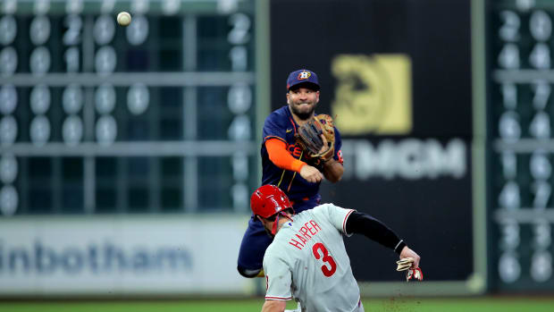 Bryce Harper slides into a base where Jose Altuve stands